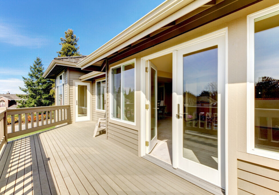 Siding house with spacious walkout deck. View of open white door